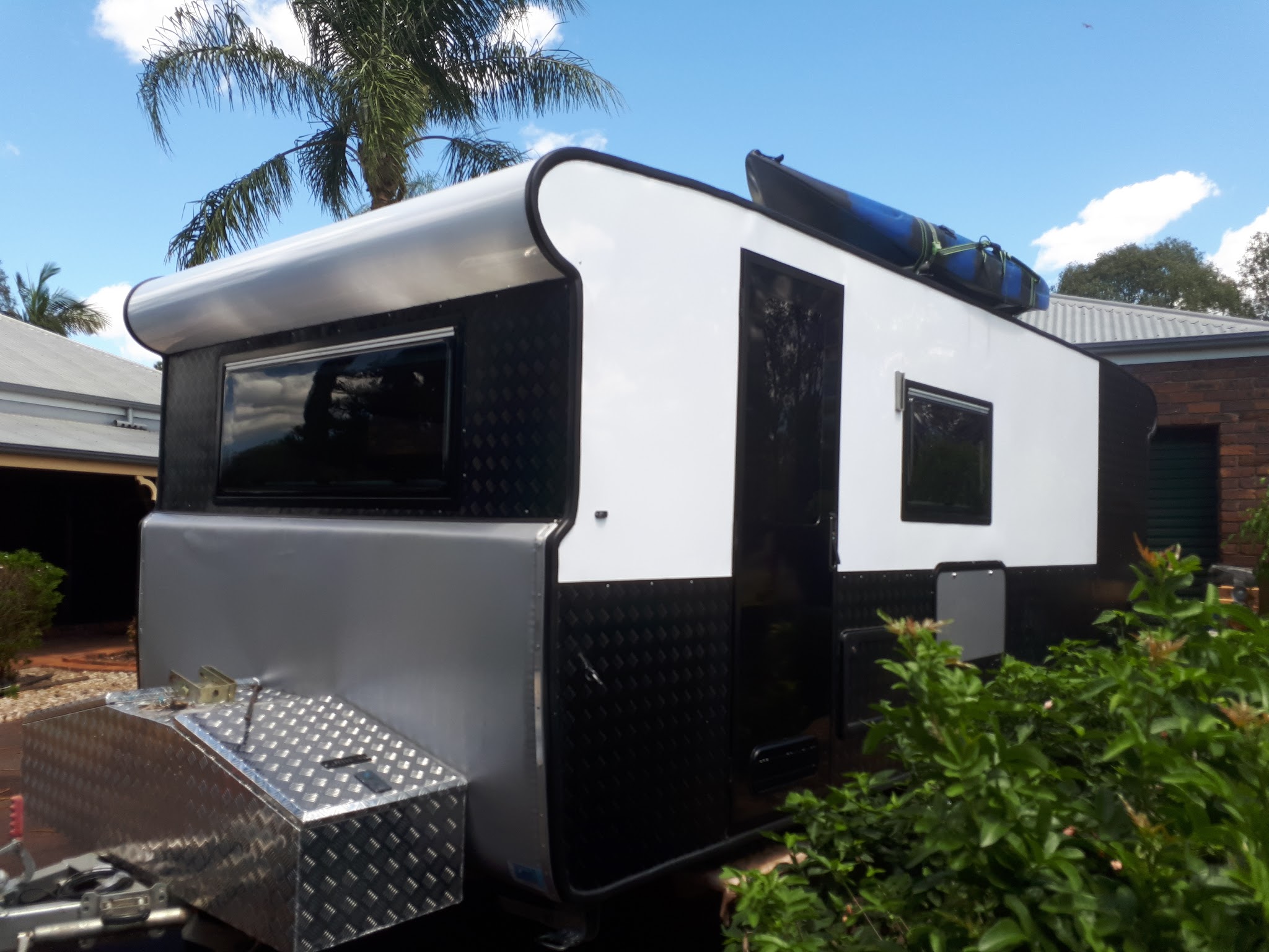 Finished off road camper trailer parked outside, kayak strapped to the roof